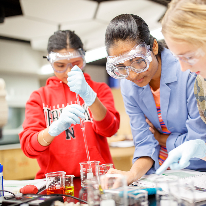 Students in goggles working on lab project together